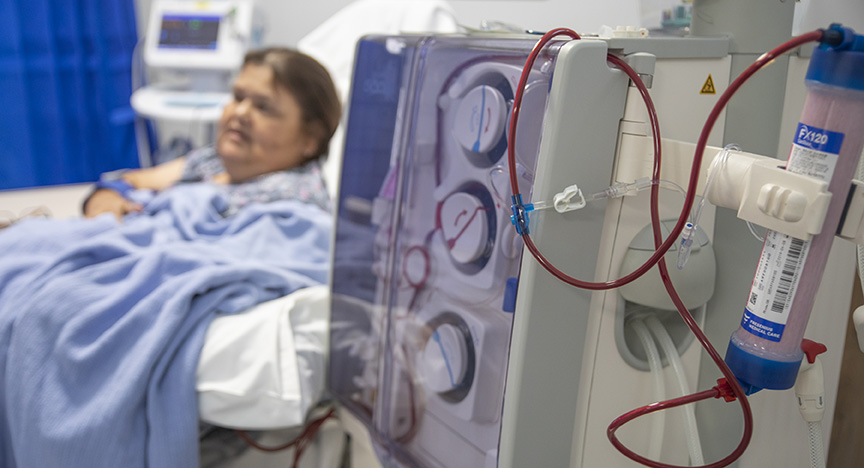 A picture of a dialysis unit, with a patient in the background.