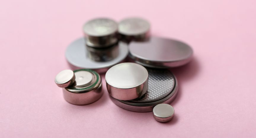 A pile of button batteries of different sizes.