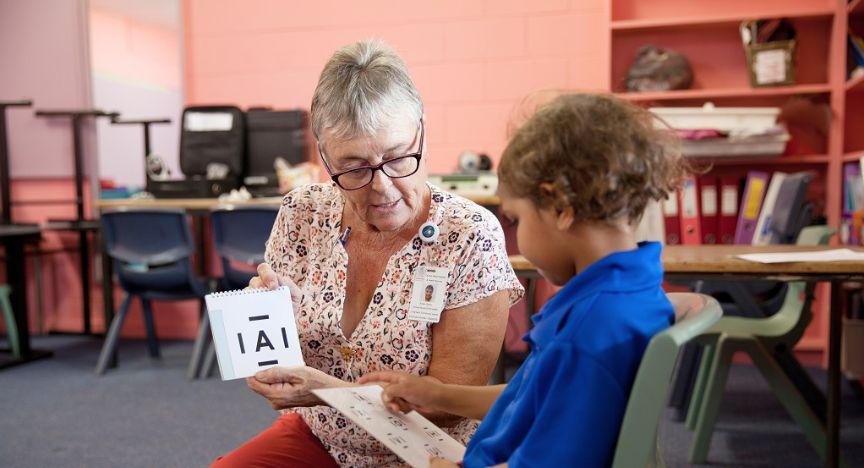 A picture of a child health nurse doing a vision check on a student