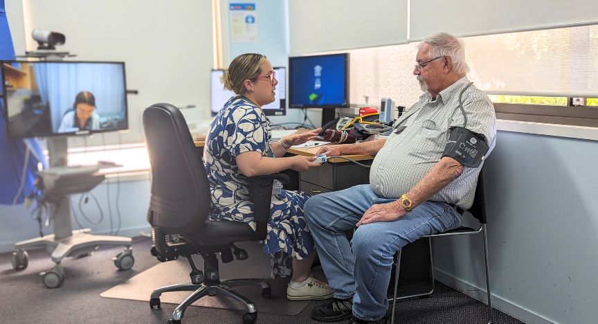 A picture of nurse Darcie White White with a patient with an ambulatory blood pressure monitor