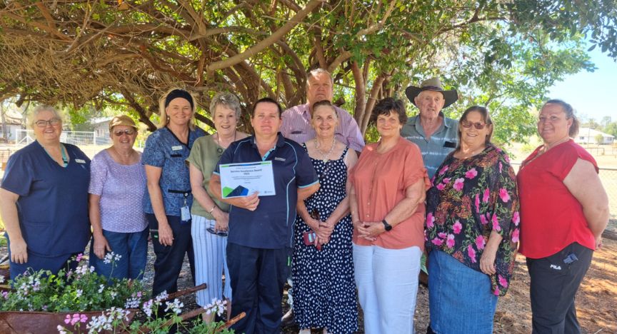 A picture of Leah Nay receiving her award with community members